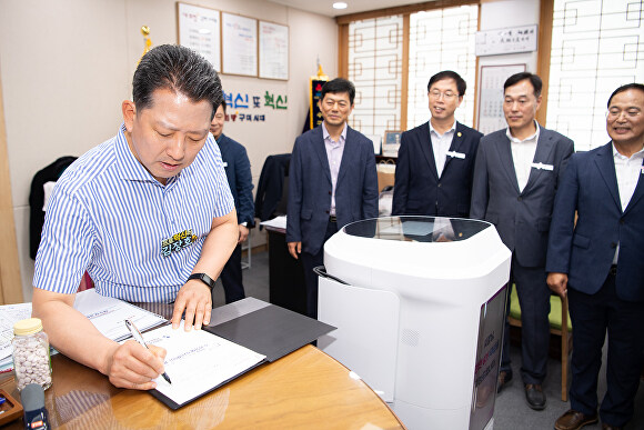 김장호 구미시장(왼쪽)이 3일 서빙로봇이 가져다 준 결제서류에 사인을 하고 있다. [사진=구미시]