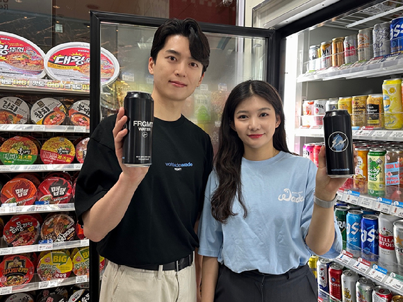GS25 모델이 '웨이드 프라그먼트' 굿즈 티셔츠를 착용하고 '웨이드 프라그먼트 탄산수'를 선보이고 있다. [사진=GS리테일]