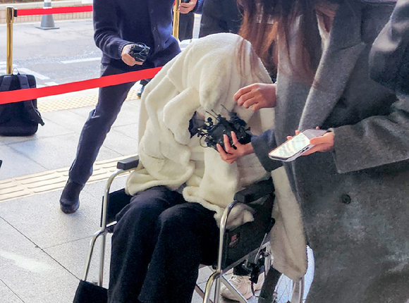 약에 취한 상태로 외제 SUV 차량을 몰고 반포대교를 달리다 한강 둔치로 추락한 운전자 A씨가 27일 서울 마포구 서부지방법원에서 열린 구속 전 피의자 심문(영장실질심사)에 옷으로 얼굴을 가리고 휠체어를 탄 채 출석하고 있다. [사진=연합뉴스]