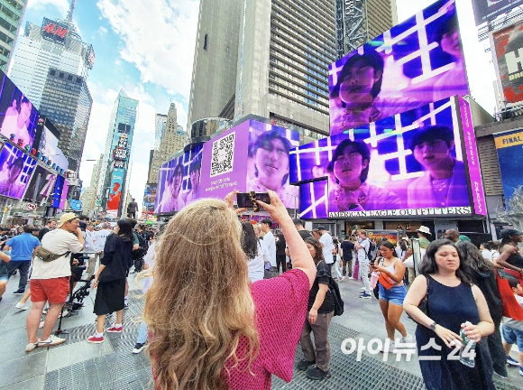 삼성전자가 10일 오후 4시(현지시간)부터 1시간 동안 뉴욕 타임스스퀘어에서 BTS와 함께 한 '갤럭시Z플립4' 홍보 영상을 상영하자, 거리를 지나던 시민이 스마트폰으로 이 모습을 촬영하고 있다. [사진=장유미 기자]