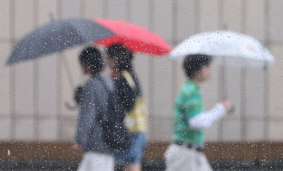 서울 경복궁 인근에서 시민들이 우산을 쓰고 길을 걷고 있다. [사진=연합뉴스]