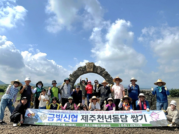 금빛신협 임직원과 내몸사랑동우회 회원이 와흘메밀마을 제주천년돌담쌓기 릴레이 프로젝트에 참가하고, 파이팅을 외치고 있다.  [사진=금빛신협]