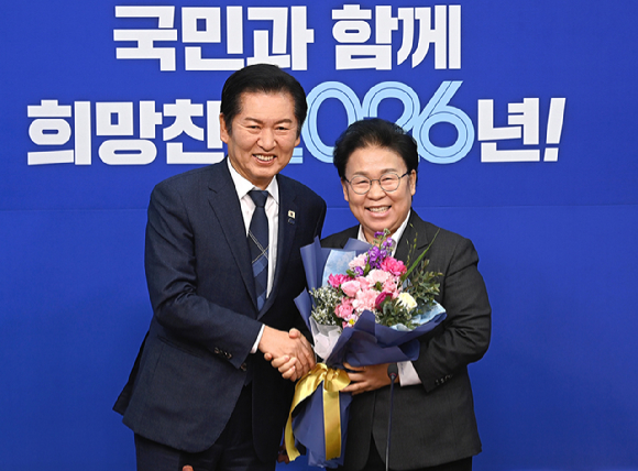  12일 서울 여의도 국회에서 열린 더불어민주당 최고위원회의에서 문정복(시흥갑&middot;재선) 신임 최고위원이 정청래 대표로부터 꽃다발을 받은 뒤 기념 촬영을 하고 있다. [사진=곽영래 기자]