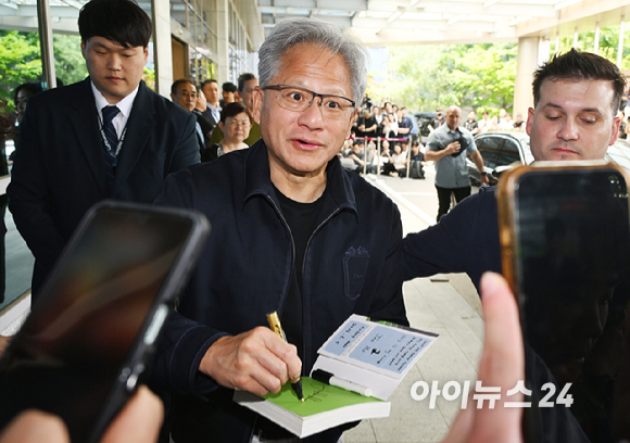 젠슨 황 엔비디아 최고경영자(CEO)가 5일 오후 전세기를 통해 서울김포비즈니스항공센터로 입국해 시민들의 사인 요청에 응하고 있다. 한 시민이 만원권 지폐에 사인을 요청하자 주머니에 넣을려는 유머스러운 제스쳐을 하며 웃는 젠슨 황의 모습. [사진=정소희 기자]