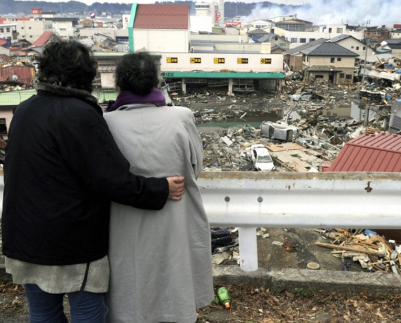 동일본 대지진이 발생한 직후인 지난 2011년 3월 15일 일본 미야기현 게센누마에서 이재민들이 폐허 속에 묻힌 자신의 집을 바라보는 모습. [사진=교도/연합뉴스]