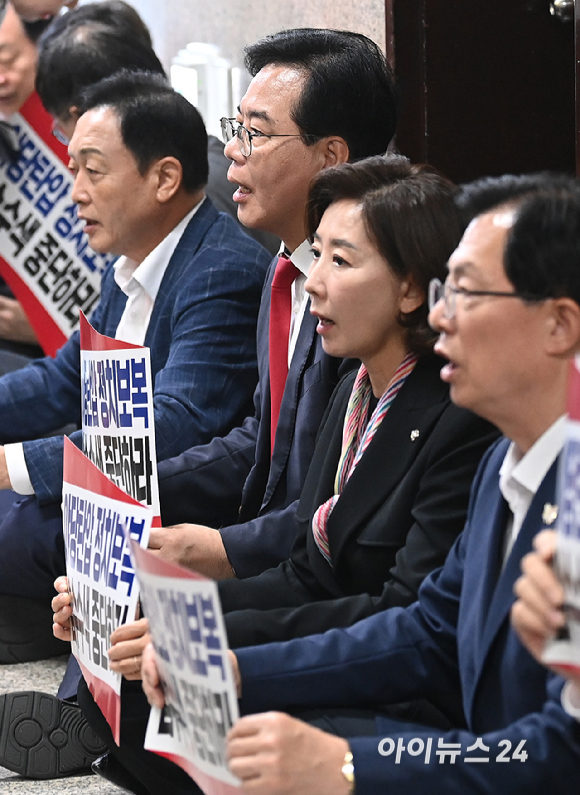 국민의힘 송언석 원내대표와 의원들이 3일 서울 여의도 국회에서 긴급의원총회 및 특검 압수수색 규탄대회를 마친 뒤 원내대표실 앞에서 압수수색 대비 연좌농성을 하고 있다. [사진=곽영래 기자]