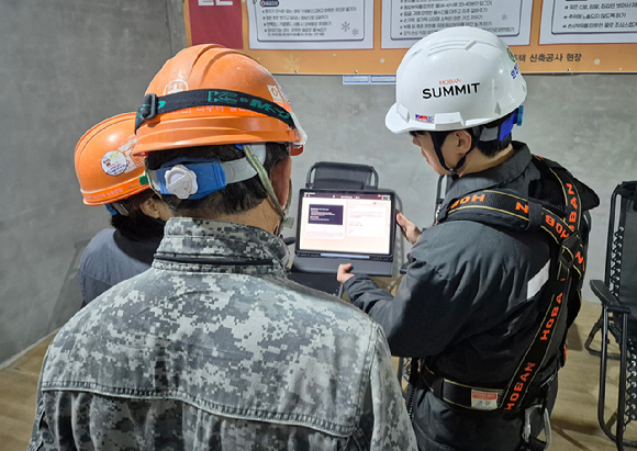 호반건설 직원이 건설 현장에서 AI 동시번역 플랫폼 ‘호반커넥트’를 활용해 근로자들과 대화하고 있다. [사진=호반건설]