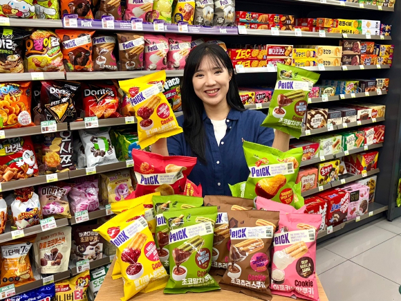 모델이 자체 브랜드 PBICK 과자 라인업을 소개하고 있다. [사진=CU]