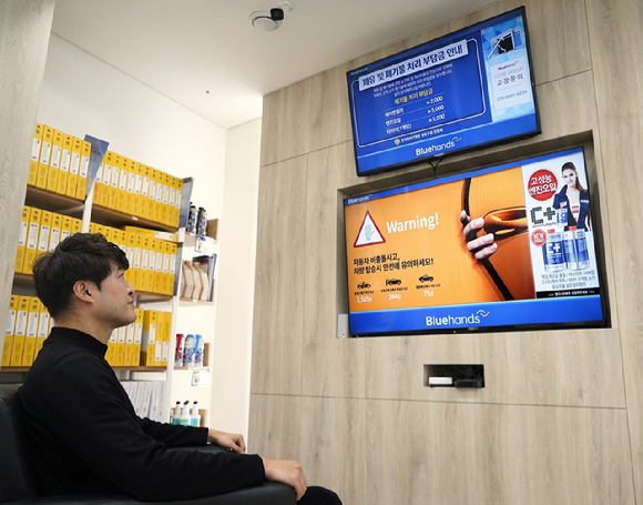 블루핸즈 매장에 방문한 고객이 SK브로드밴드 'B tv 온애드' 화면을 바라보고 있는 모습 [사진=SKB]