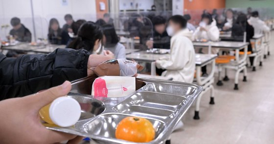 학교비정규직노동자들이 정규직과 임금 차별 해소 등을 요구하며 총파업에 돌입한 가운데 25일 서울의 한 중학교에서 학생들이 급식 대신 샌드위치와 머핀 등 대체 급식을 받아가고 있다. [사진=사진공동취재단]
