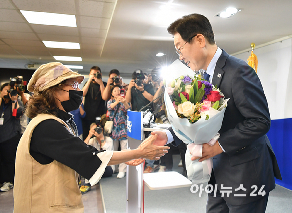 이재명 전 더불어민주당 대표가 10일 오전 서울 여의도 더불어민주당 중앙당사에 당 대표 출마 기자회견에서 지지자에게 꽃다발을 받고 있다.