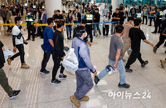 미국 이민당국에 의해 조지아주에 구금됐던 한국인 근로자들이 12일 인천국제공항 제2여객터미널 입국장을 나서고 있다. 작업복을 입은 상태로 귀국하는 근로자의 모습. [사진=정소희 기자]