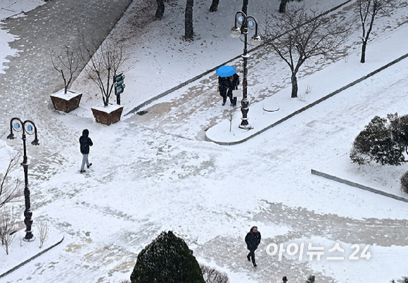 밤 사이 눈이 내린 20일 오전 서울 여의도 공원에서 시민들이 얼어붙은 빙판길을 걷고 있다. [사진=곽영래 기자]