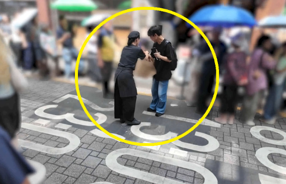성심당 직원이 시각장애인 유튜버 한솔의 빵 구매 후 빵이 든 쇼핑백을 건네고 있다. [사진=원샷한솔 유튜브 캡처]