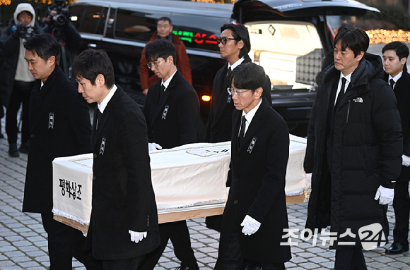 9일 서울 중구 명동성당에서 열린 故 안성기의 장례 미사가 끝난 뒤 영결식을 위해 고인의 영정과 금관문화훈장을 든 배우 정우성, 이정재가 영결식장으로 향하고 있다. [사진=곽영래 기자]