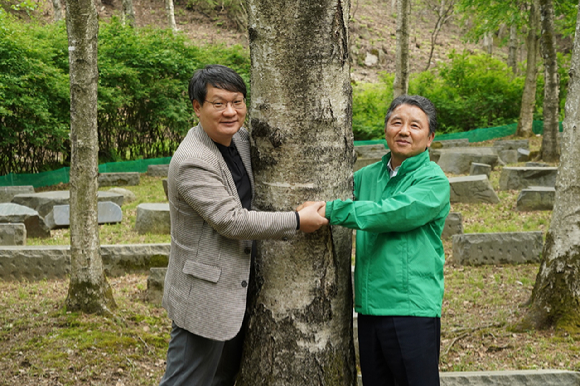 남성현 산림청장(오른쪽)이 30일 충북 충주시 SK임업 산림경영지를 방문해 손대익 SK임업 대표와 50년 자란 자작나무를 안아보고 있다. [사진=산림청]