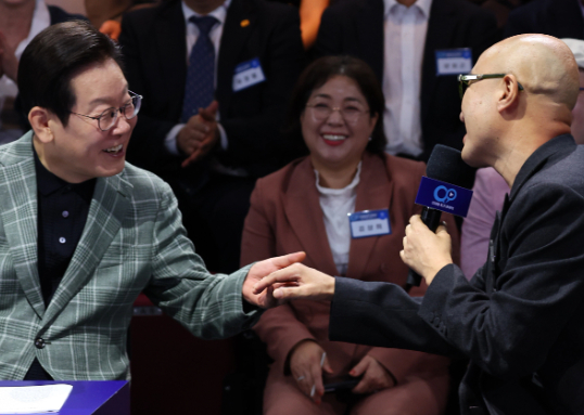 이재명 대통령이 지난 14일 서울 동대문구 콘텐츠문화광장에서 열린 디지털토크라이브 '국민의 목소리, 정책이 되다' 간담회에서 자영업 멘토로 참석한 방송인 홍석천과 인사하고 있다. [사진=연합뉴스]