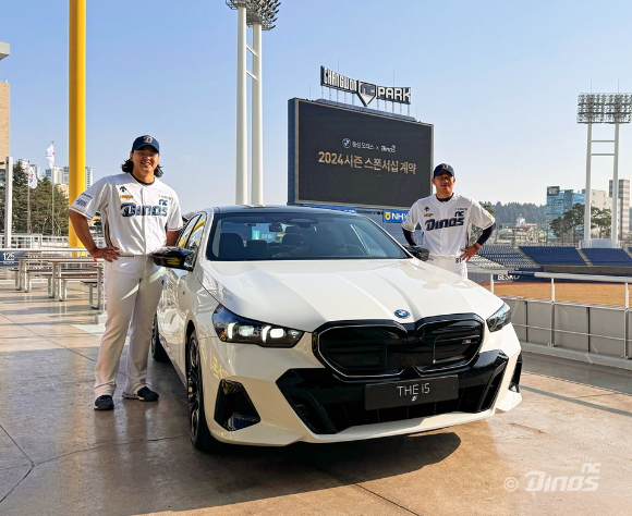 NC 다이노스 투수 송명기, 김시훈(이상 왼쪽부터)이 BMW i5과 함께 포즈를 취하고 있다. [사진=동성 모터스/NC 다이노스]