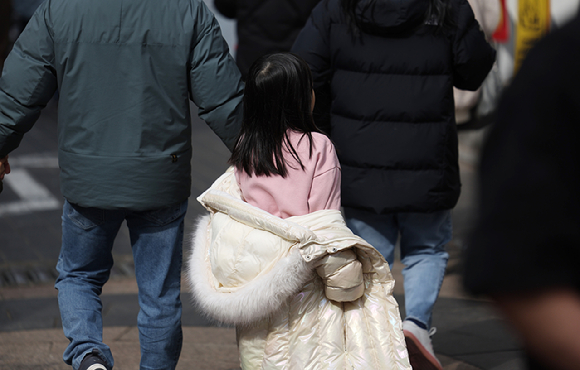 지난달 28일 서울 중구 명동 거리에서 한 아이가 외투를 반쯤 입은 채로 이동하고 있다. [사진=연합뉴스]