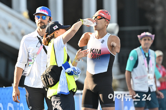 김황태가 2일(현지시간) 프랑스 파리 알렉상드로 3세 다리 인근에서 열린 2024 파리 패럴림픽 남자 트라이애슬론(철인 3종) PTS3 등급 경기에서 스타트 직전 핸들러(경기 보조인)인 아내 김진희 씨의 도움을 받고 있다. [사진=사진공동취재단]