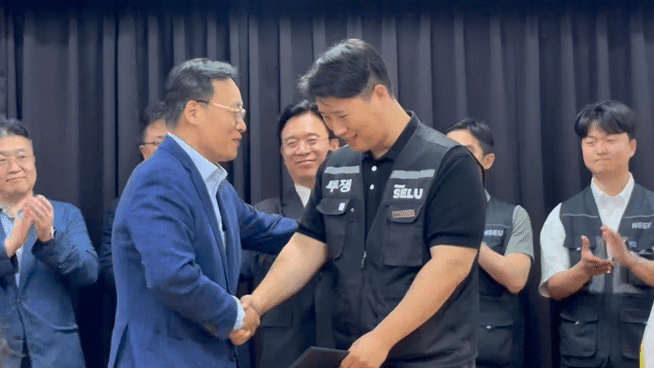 여명구 삼성전자 부사장과 최승호 초기업노조 삼성전자 지부 위원장이 20일 수원 경기고용노동청에서 열린 노사 대화를 합의로 마무리하고 함께 파이팅을 외치고 있다. [사진=권서아 기자]