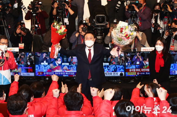 윤석열 제20대 대통령 당선인이 10일 새벽 국회 도서관에 마련된 개표상황실을 찾아 당선 축하 꽃다발을 들어보이고 있다. [사진=김성진 기자]