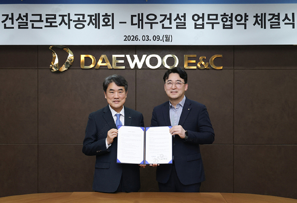 권혁태 건설근로자공제회 전무이사(이사장 직무대행, 왼쪽)와 신동혁 대우건설 CFO(오른쪽)이 &lsquo;현장 노동자 전자카드 정보 연계&rsquo;업무협약을 체결하고 있다. [사진=대우건설]