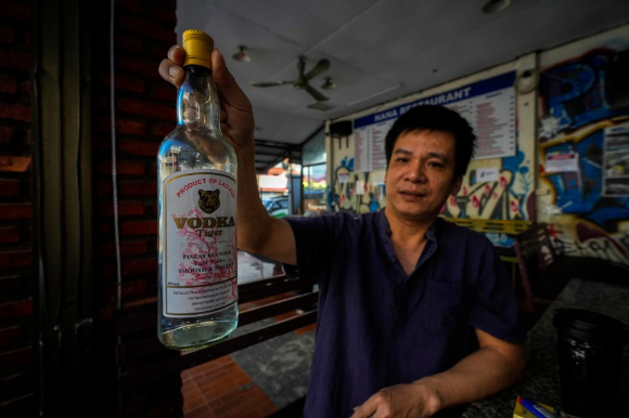 지난 19일(현지 시각) 라오스 방비엥의 한 호스텔 매니저가 이 곳에서 파는 보드카를 들어보이고 있다. 이 호스텔에 투숙한 호주 여성 2명이 메탄올 중독 증상을 보여 1명이 숨지고 1명은 중태다. [사진=연합뉴스]