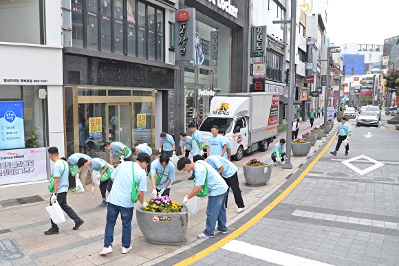 부산롯데타워TF팀이 지난 25일 광복동 일대에서 쓰레기 줍기 활동을 하고 있다. [사진=롯데쇼핑]