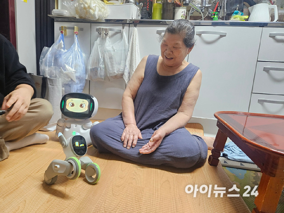 정순자 할머니가 돌봄로봇 '루나'의 반응을 보며 환한 미소를 띄고 있다. [사진=설재윤 기자]