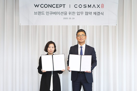 안지수 W컨셉 상품기획담당(왼쪽)과 최재우 코스맥스 국내마케팅본부 부문장(오른쪽)이 업무협약 체결 후 기념사진을 촬영하고 있다. [사진=W컨셉]