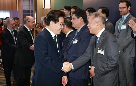 이재명 대통령이 28일(현지시간) 브라질 상파울루 한 호텔에서 열린 한-브라질 비즈니스 라운드테이블에 입장하며 정의선 현대차그룹 회장과 악수하고 있다. [사진=연합뉴스]