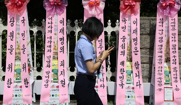 31일 서울 여의도 국회 앞에 이재명 더불어민주당 대표의 취임 1주년을 응원하는 화환들이 설치되어 있다.  [사진=뉴시스]