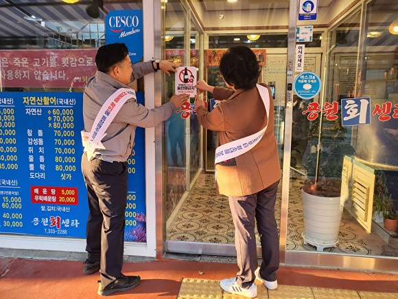 지난 15일 경상남도 김해시 공무원 등이 관내 일반음식점에 '청소년 주류판매 금지' 홍보 스티커를 부착하고 있다. [사진=경상남도 김해시]