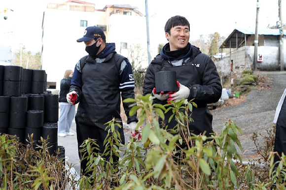 두산 베어스는 7일 서울시 도봉구에서 사랑의 연탄 나눔 행사를 가졌다. 이날 참석한 두산 허경민(오른쪽)이 배달 도중 환하게 미소짓고 있다. [사진=두산 베어스]