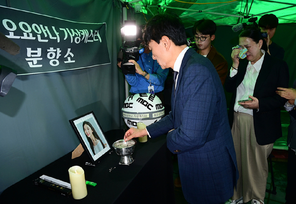 MBC가 15일 오전 서울 상암동 MBC신사옥에서 기상캐스터 故 오요안나의 유족과 합의를 하고 어머니 장연미 씨에게 故 오요안나 명예사원증 전달식을 가졌다. 사원증 보는 고인의 어머니와 안형준 MBC 사장. [사진=정소희 기자]