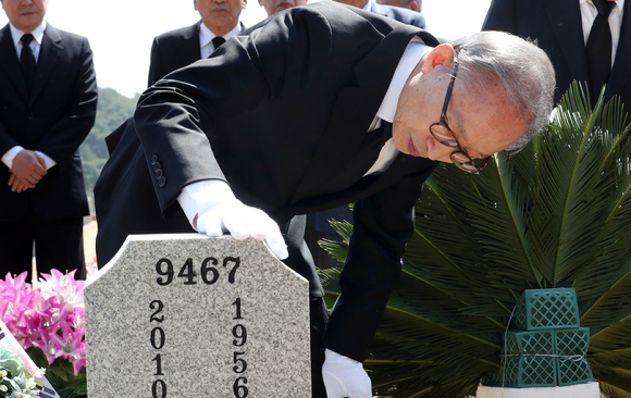 이명박 전 대통령이 22일 대전시 유성구 국립대전현충원 천안함 46용사 묘역을 참배한 뒤 묘비를 살펴보고 있다. [사진=뉴시스]
