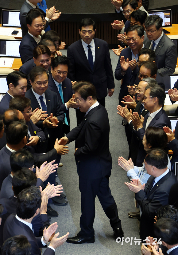 이재명 대통령이 26일 오전 서울 여의도 국회에서 열린 제426회국회(임시회) 제2차 본회의에서 2025년도 제2회 추가경정예산안 시정연설을 위해 본회의장으로 들어서며 의원들과 인사나누고 있다. [사진=국회사진기자단]