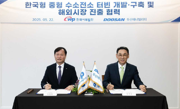 지난 22일 두산에너빌리티 창원 본사에서 진행된 한국형 중형 수소전소 터빈 개발·실증 양해각서(MOU) 체결식에서 정연인 두산에너빌리티 부회장(오른쪽)과 이정복 한국서부발전 사장이 서명하고 있다. [사진=두산에너빌리티]