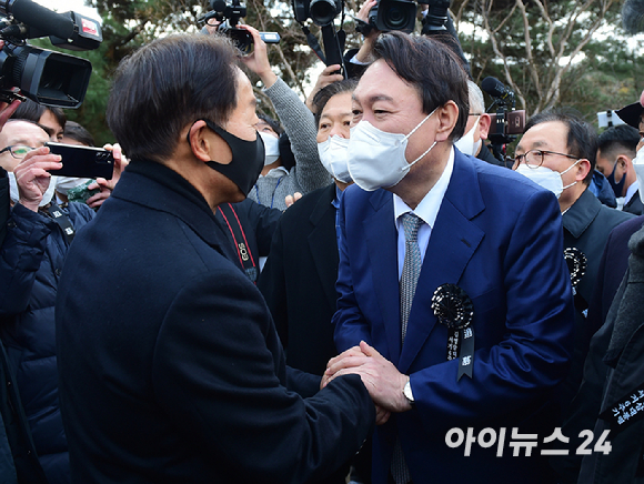 윤석열 국민의힘 대선 후보가 22일 서울 동작구 국립서울현충원 내 김영삼 전 대통령 묘역에서 열린 6주기 추모식에서 차남인 김현철 김영삼민주센터 상임이사와 인사를 나누고 있다. [사진=국회사진취재단]