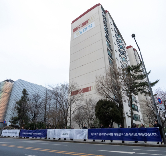 DL이앤씨 임직원들이 현수막을 들고 압구정5구역에서 출근길 인사를 하고 있다. [사진=DL이앤씨]