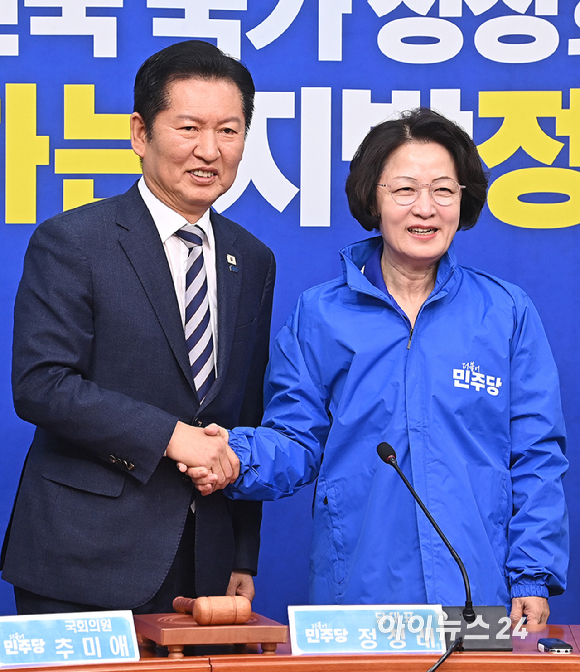 더불어민주당 정청래 대표가 13일 서울 여의도 국회에서 열린 최고위원회의에 앞서 추미애 경기도지사 후보에게 당 점퍼를 입혀주고 있다. [사진=곽영래 기자]