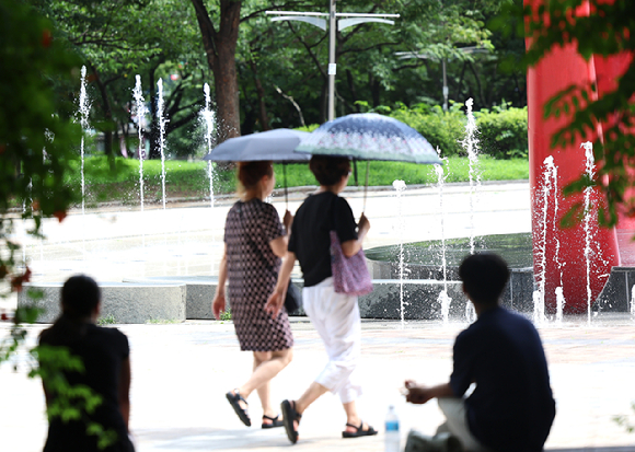 인천 남동구 중앙공원에서 시민들이 분수대에서 나오는 물줄기를 보며 더위를 식히고 있다. [사진=뉴시스]