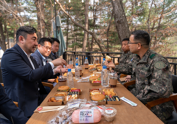 신세계푸드 송현석 대표(사진 왼쪽)가 22일 육군 28보병사단을 방문, 박춘식 사단장(사진 오른쪽)에게 '베러미트'로 만든 메뉴를 소개하고 있다. [사진=신세계푸드]