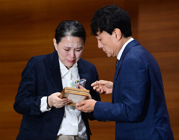 MBC가 15일 오전 서울 상암동 MBC신사옥에서 기상캐스터 故 오요안나의 유족과 합의를 하고 어머니 장연미 씨에게 故 오요안나 명예사원증 전달식을 가졌다. 사원증 보는 고인의 어머니와 안형준 MBC 사장. [사진=정소희 기자]