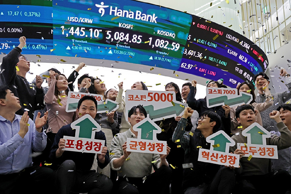 종가 기준 코스피 지수가 5,000선&middot; 코스닥이 1,000선을 동시에 돌파한 27일 서울 중구 하나은행 딜링룸에서 직원들이 기념 세레머니를 하고 있다. [사진=연합뉴스]