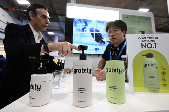 세계 최대 가전&middot;정보기술(IT) 전시회 'CES 2026' 이틀째인 7일(현지시간) 미국 네바다주 라스베이거스 베네치안엑스포 내 유레카파크에서 관람객이 KAIST 연구진이 개발한 탈모 기능성 샴푸 '그래비티'에 대한 설명을 듣고 있다. [사진=그래비티]