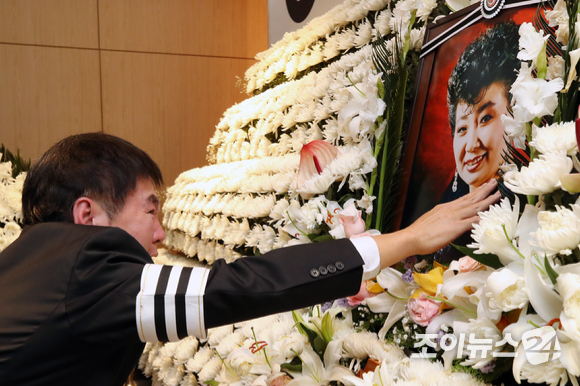 11일 오전 서울 동작구 중앙대병원 장례식에서 열린 원로가수 고 현미 영결식에서 아들 이영곤 씨가 헌화하며 눈물을 흘리고 있다. [사진=김성진 기자]