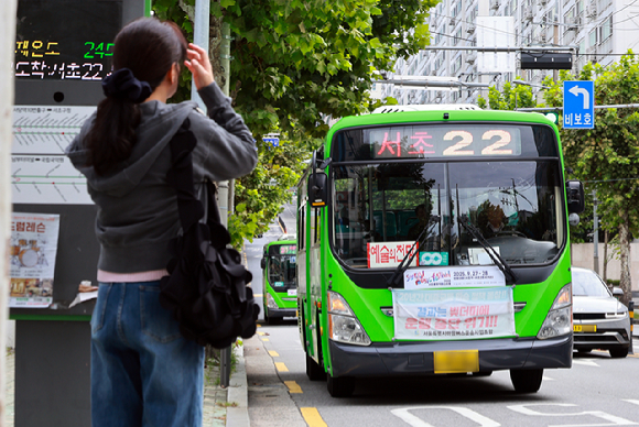대중교통 환승할인 보전 규모를 놓고 서울시와 갈등을 빚고 있는 서울시마을버스운송사업조합이 22일 요구안이 수용되지 않으면 내년 1월 1일부터 환승제도에서 공식 탈퇴하겠다고 밝혔다. 사진은 서울 시내 버스정류장에서 한 시민이 마을버스를 기다리는 모습. [사진=연합뉴스]