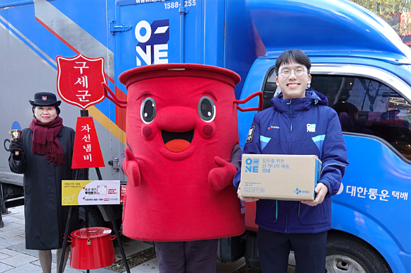 CJ대한통운 오네(O-NE) 배송차량 앞에서 CJ대한통운 직원과 구세군 사관, 구세군 캐릭터 따끈이가 10주년 기념촬영을 하고 있다. [사진=CJ대한통운]